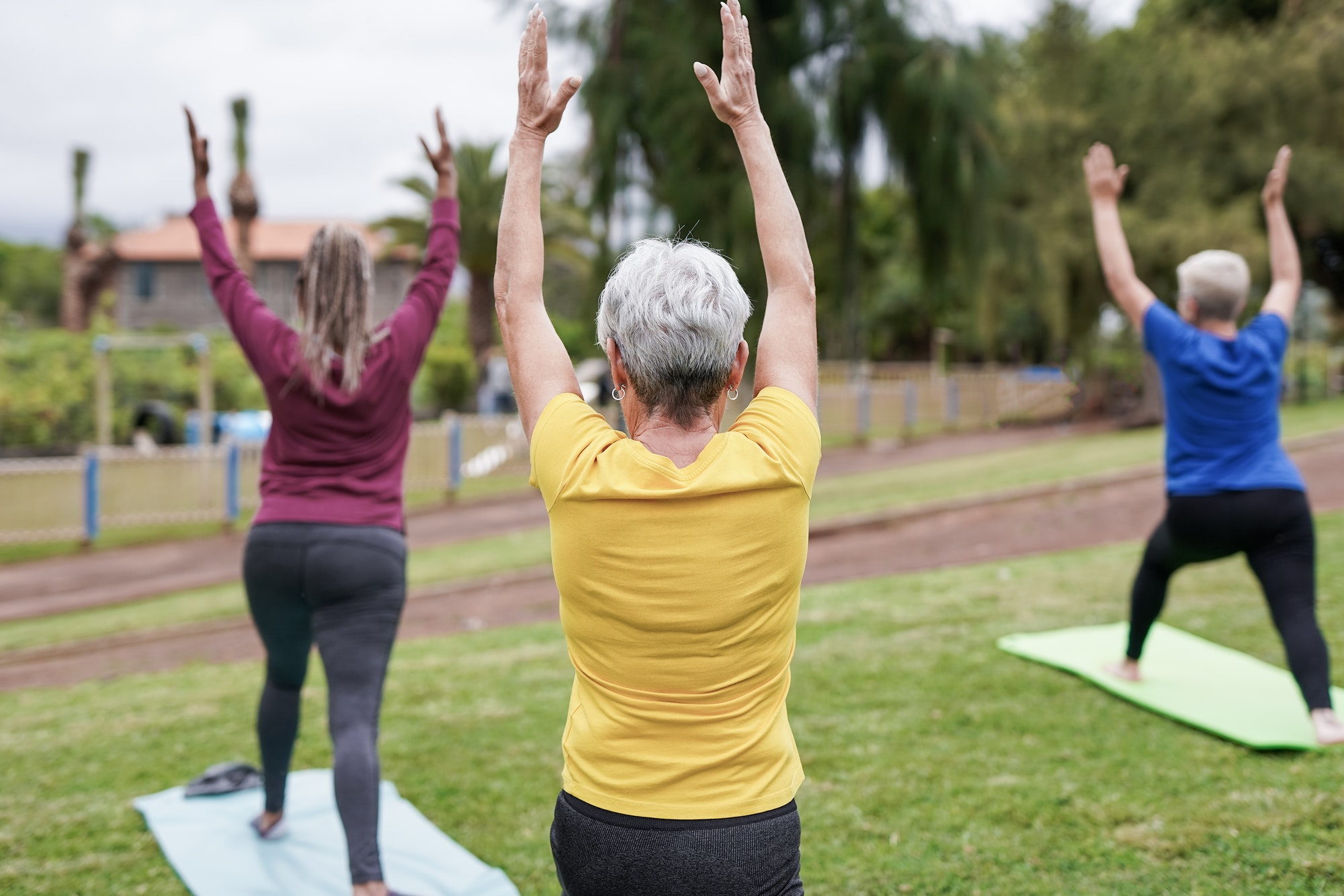 Multiracial senior women doing yoga exercise at city park
